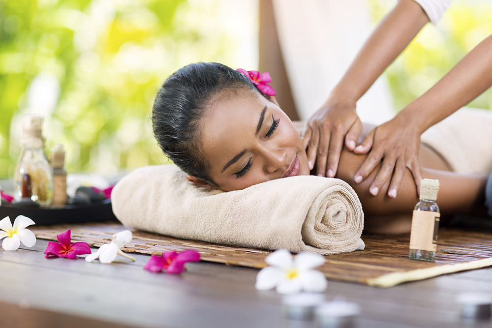 A Woman Experiencing Back Massage By a Professional Massage Therapist in a luxurious massage center.