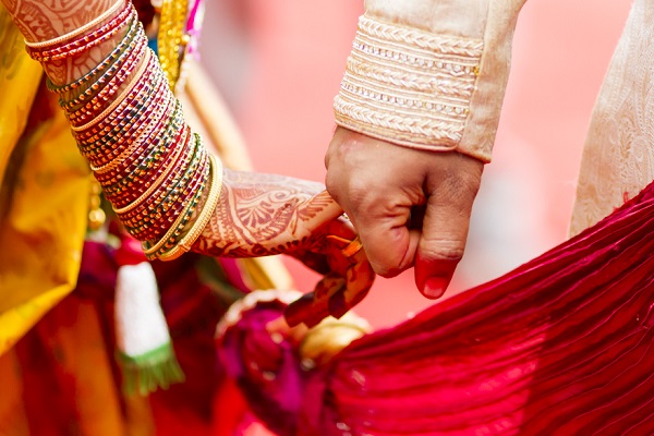 A Beautiful Capture of An Indian Bride and Groom Holding Their Hands during the wedding ritual. 